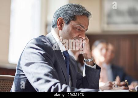 Businessman writing notes during meeting Stock Photo