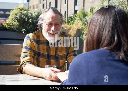 Senior man holding woman's hands at table Stock Photo