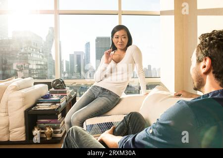 Young couple on sofa in New York City apartment Stock Photo