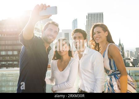 Friends taking selfie on balcony in New York City Stock Photo