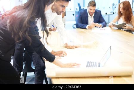 Colleagues using laptop in meeting Stock Photo