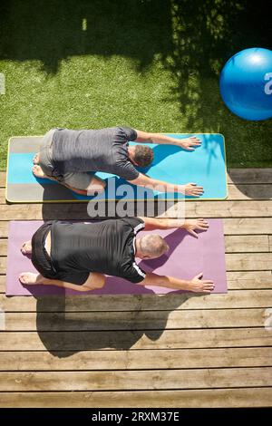 Mature couple practicing yoga in back yard Stock Photo