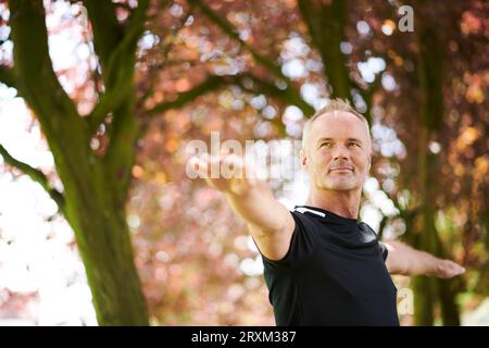 Mature man practicing yoga in park Stock Photo