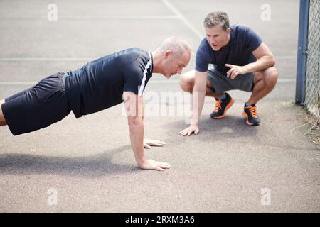 Mature men doing push-ups Stock Photo
