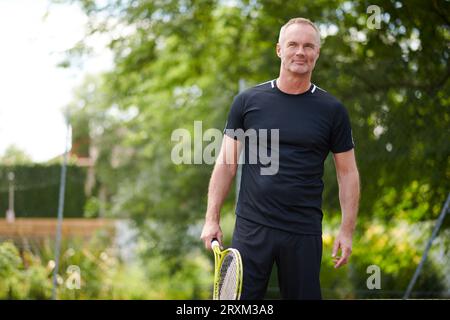 Mature man holding tennis racket Stock Photo