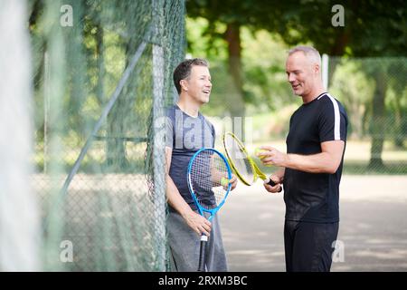 Mature men on tennis court Stock Photo