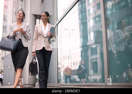 Businesswomen walking on sidewalk Stock Photo
