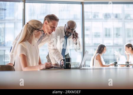 Colleagues using laptop Stock Photo