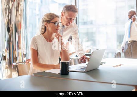 Colleagues using laptop Stock Photo