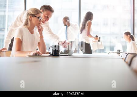 Colleagues using laptop Stock Photo