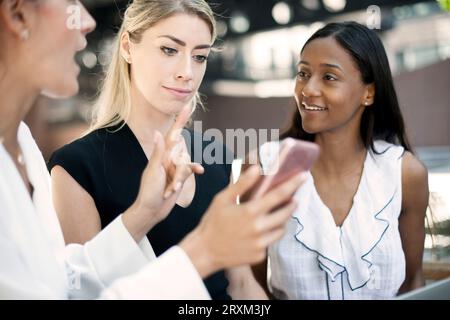 Colleagues using smart phone Stock Photo