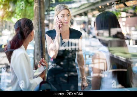 Businesswoman on phone by colleagues Stock Photo