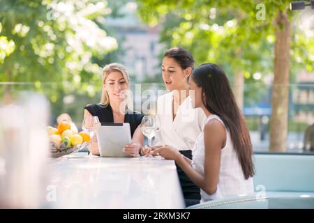 Businesswomen using digital tablet at restaurant Stock Photo
