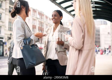 Colleagues talking on sidewalk Stock Photo