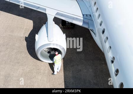 High angle view of man working on airplane engine Stock Photo