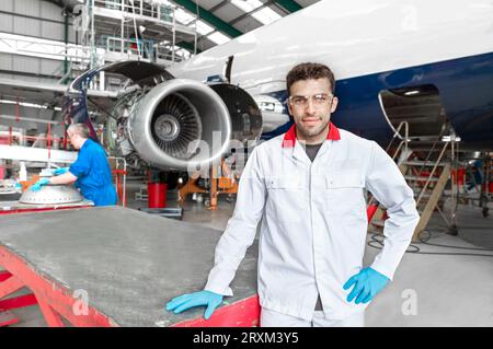 Portrait of young male worker in airplane hangar Stock Photo