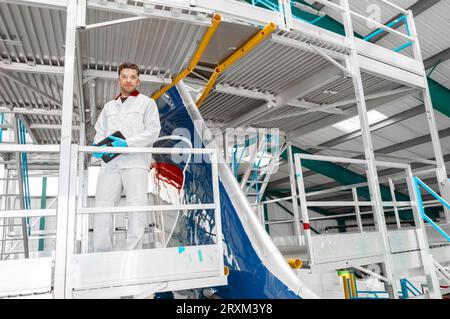 Male worker holding digital tablet in airplane hangar Stock Photo