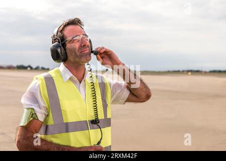 Man wearing headset on airport runway Stock Photo