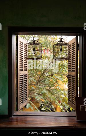 Lights in window with open shutters Stock Photo