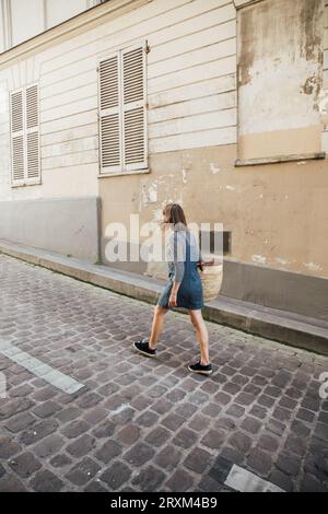 Young woman wearing denim dress on street Stock Photo