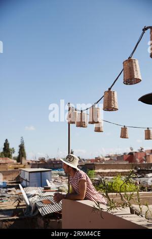 Man wearing straw hat on rooftop with lanterns Stock Photo