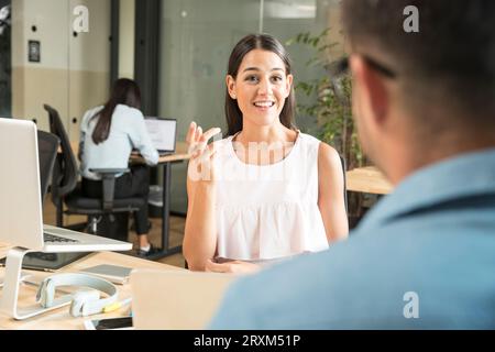 Young woman talking during meeting Stock Photo