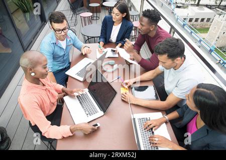 Businesspeople with laptops during meeting on balcony Stock Photo