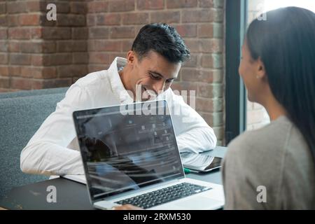 Smiling businessman during meeting with laptop Stock Photo