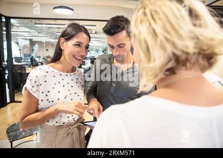 Colleagues using digital tablet in office Stock Photo