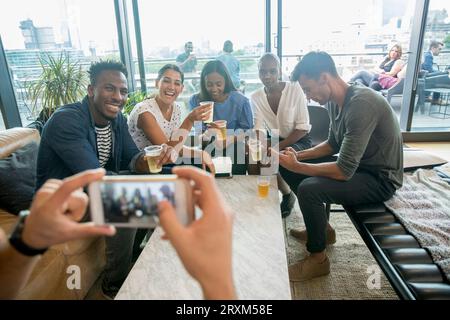 Colleagues posing for photograph with drinks Stock Photo