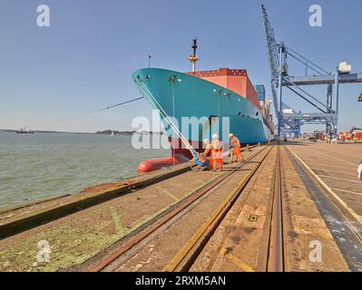 Dock workers attach moorings to cargo ship at Port of Felixstowe, England Stock Photo