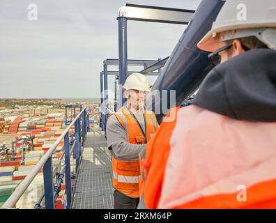 Dock workers standing by railing on crane Stock Photo