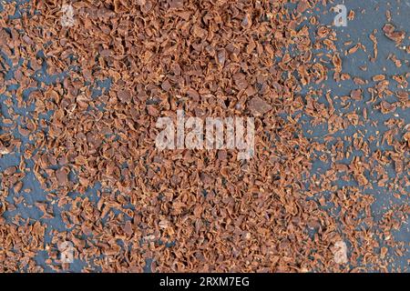 a large number of pieces and crumbs of chocolate scattered on the surface, using small pieces of chocolate in cooking Stock Photo