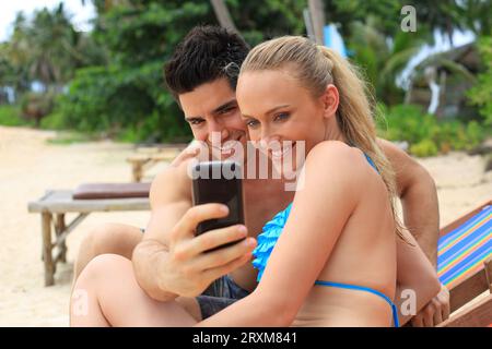 Young couple taking selfie on beach Stock Photo