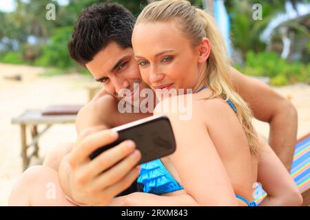 Young couple taking selfie on beach Stock Photo