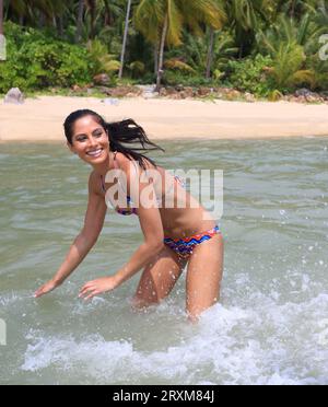 Young woman wearing bikini splashing in sea Stock Photo