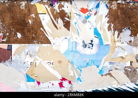 City billboard with torn damaged paper, posters on surface as texture or background Stock Photo