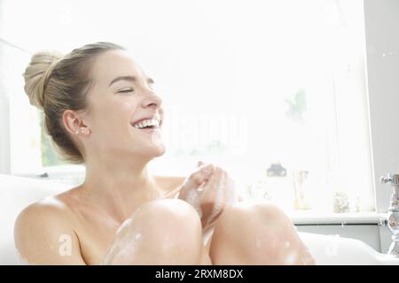 Woman smiling in a bubble bath Stock Photo