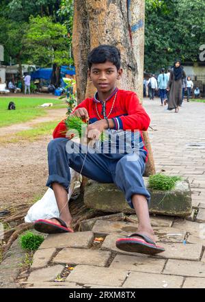 MUMBAI - SEPT 21: Indian boy sitting on the ground at public city park in Mumbai on September 21. 2022 in India Stock Photo