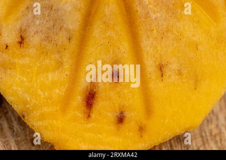 Half-ripe orange persimmon, fresh ripe persimmon cut into pieces on a cutting board with a sharp knife Stock Photo