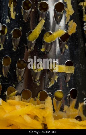 Finely grated yellow carrots in the kitchen, several peeled and washed carrots grated into pieces on a grater Stock Photo