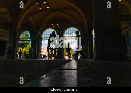 Silhouette of blurred cyclists traveling on the cycle path under the central station. Stock Photo
