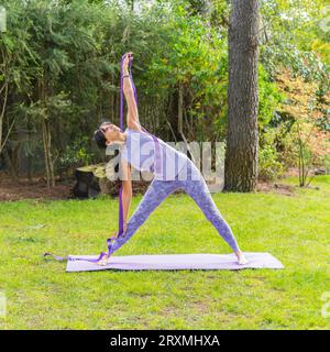 Portrait of sporty woman in sportswear working out with strap outdoor. Stock Photo