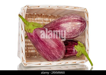 Three organic ripe eggplants in a basket, macro, isolated on white background. Stock Photo