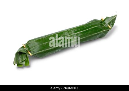 Single whole Lemper wrapped in banana leaves, an Indonesian savoury snack made of glutinous rice  close up isolated on white background Stock Photo