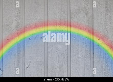 Wooden wall background with a rainbow Stock Photo
