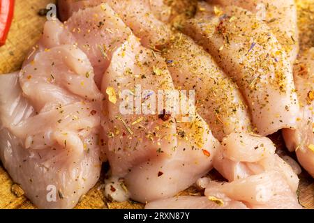 Freshly washed and skinned chicken meat, chicken fillets with salt and spices ready for cooking Stock Photo