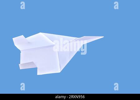 White paper plane isolated on blue background Stock Photo
