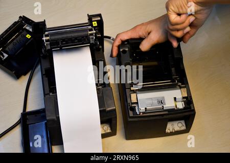 Top view. Technician repairing printer, thermal printer. Stock Photo