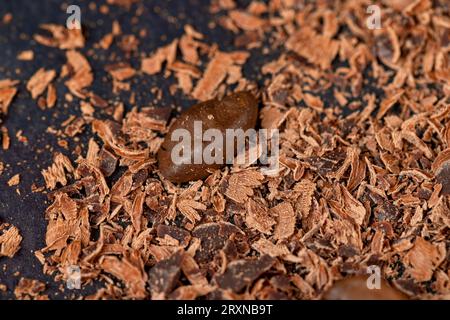 Roasted coffee beans lie together with chocolate crumbled into small pieces, fragrant coffee together with chocolate crumbs Stock Photo